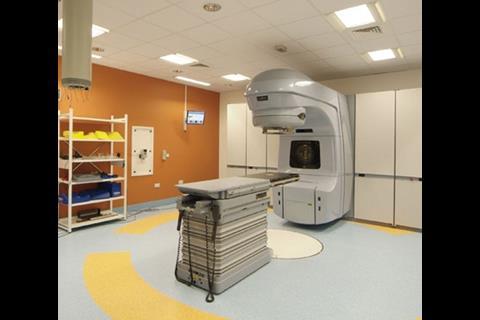 On the ground floor, a linear accelerator dispenses high-tech radiotherapy in the hospital’s cancer care centre